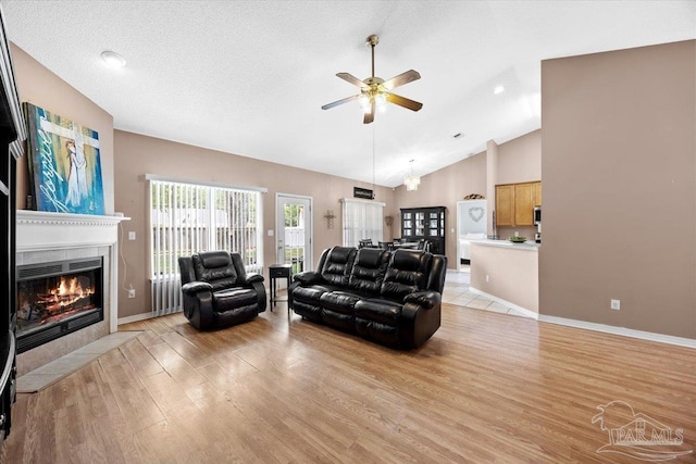 5761 Twisted Oak Ct, Pace, FL 32571 - living area with high vaulted ceiling, light wood-type flooring, a ceiling fan, baseboards, and a tile fireplace