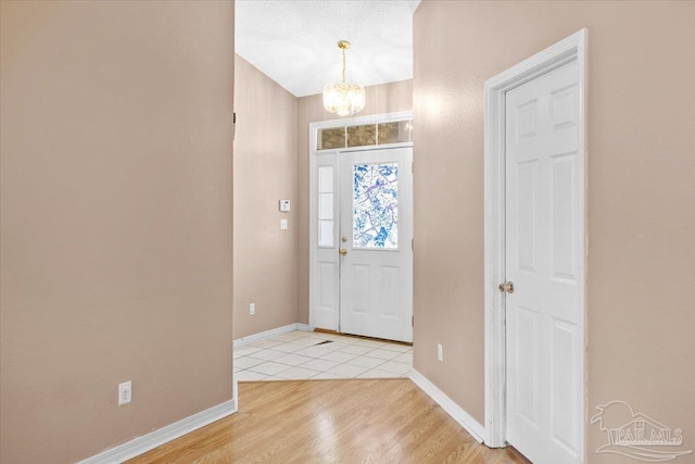 5761 Twisted Oak Ct, Pace, FL 32571 - entrance foyer featuring an inviting chandelier, light wood-style floors, and baseboards