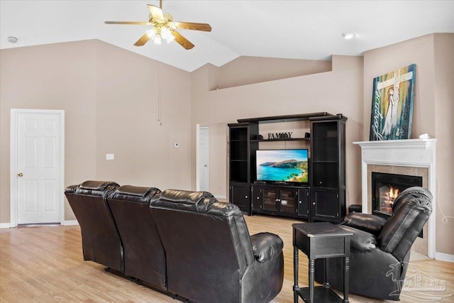5761 Twisted Oak Ct, Pace, FL 32571 - home theater featuring vaulted ceiling, light wood-style flooring, a ceiling fan, and a warm lit fireplace