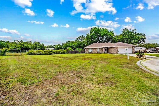 5761 Twisted Oak Ct, Pace, FL 32571 - view of yard featuring fence, an attached garage, and driveway