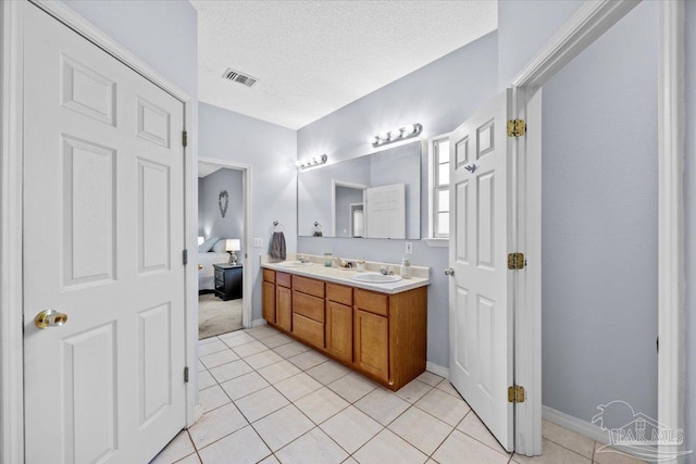 5761 Twisted Oak Ct, Pace, FL 32571 - bathroom featuring double vanity, a sink, visible vents, baseboards, and tile patterned flooring