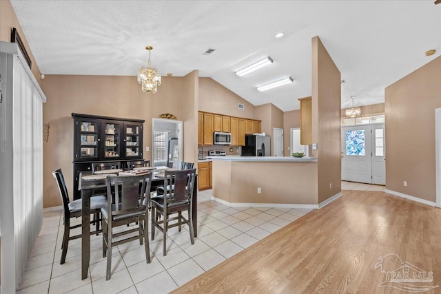 5761 Twisted Oak Ct, Pace, FL 32571 - dining room featuring high vaulted ceiling, an inviting chandelier, baseboards, and light wood-type flooring