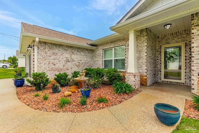 1606 Ponderosa Dr, Gulf Breeze, FL 32563 - doorway to property with brick siding and roof with shingles