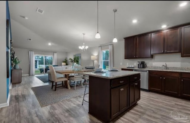 kitchen with stainless steel dishwasher, a notable chandelier, dark brown cabinets, and light wood finished floors
