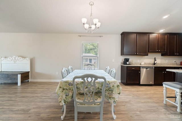 dining area with baseboards, a chandelier, and light wood-type flooring