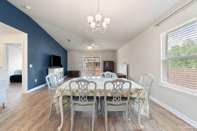 dining room featuring light wood-type flooring, lofted ceiling, and baseboards