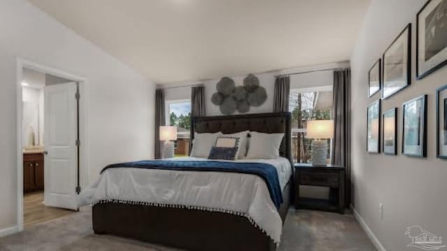 bedroom featuring lofted ceiling, baseboards, and multiple windows