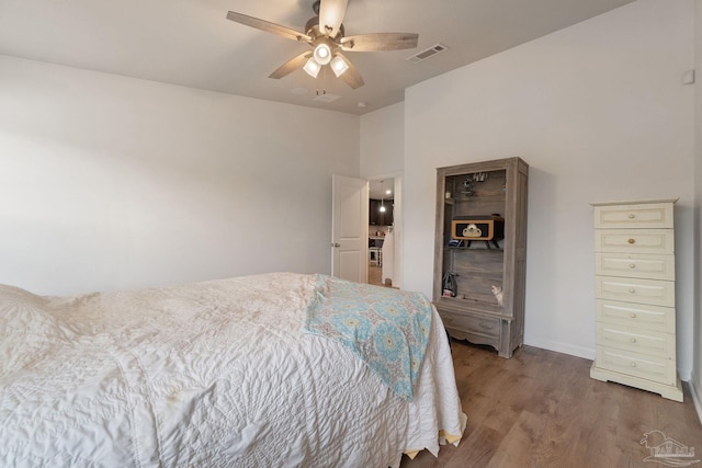 bedroom featuring light wood-style flooring, visible vents, baseboards, and ceiling fan