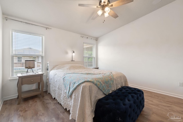 bedroom featuring ceiling fan, vaulted ceiling, wood finished floors, and baseboards
