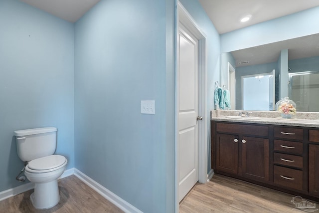 full bathroom with toilet, baseboards, an enclosed shower, wood finished floors, and vanity