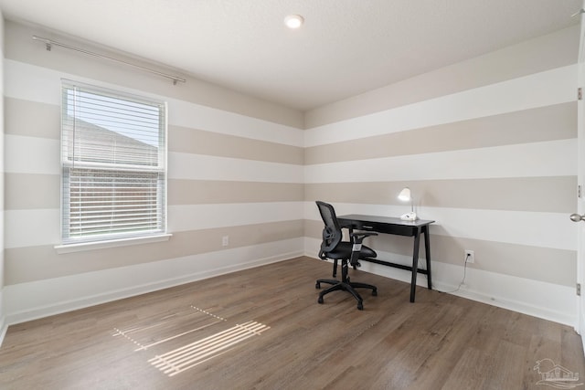 home office featuring wood finished floors and a healthy amount of sunlight