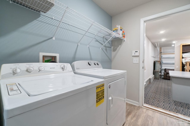 laundry room featuring baseboards, light wood-type flooring, laundry area, and washer and clothes dryer