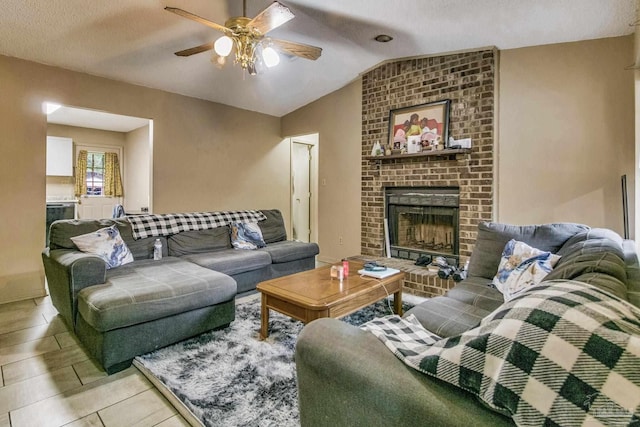 living room featuring lofted ceiling, ceiling fan, and a brick fireplace