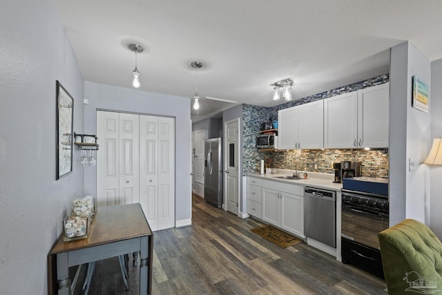 kitchen featuring tasteful backsplash, decorative light fixtures, appliances with stainless steel finishes, dark hardwood / wood-style flooring, and white cabinets