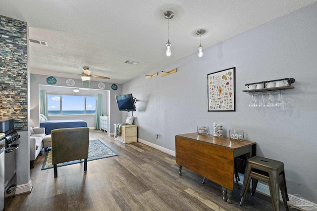 office area featuring ceiling fan, a textured ceiling, and dark hardwood / wood-style flooring