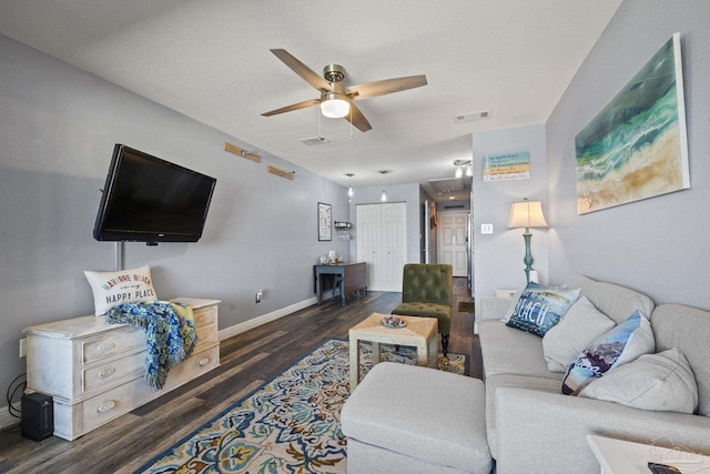 living room featuring dark hardwood / wood-style floors, a textured ceiling, and ceiling fan