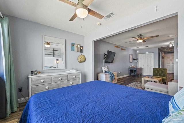 bedroom with dark hardwood / wood-style floors and ceiling fan