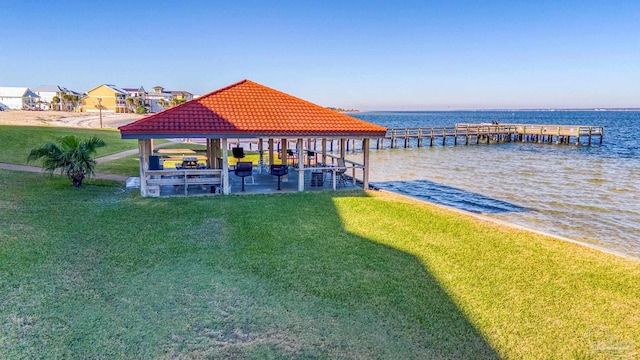 view of dock with a yard, a gazebo, and a water view