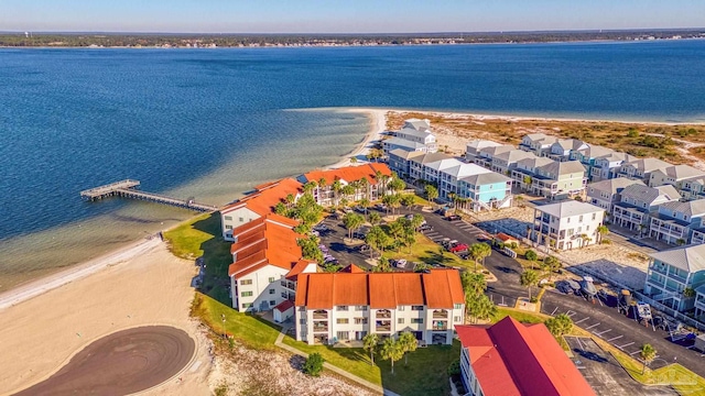 birds eye view of property with a water view and a beach view