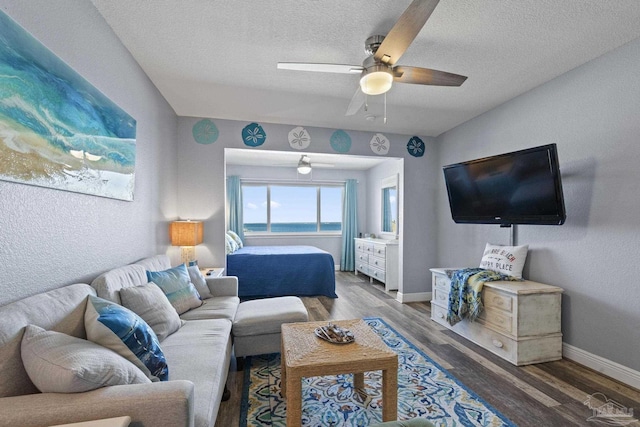 bedroom with ceiling fan, dark hardwood / wood-style flooring, and a textured ceiling