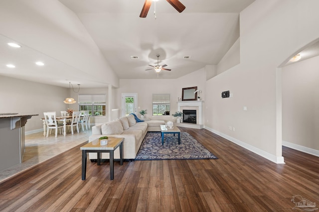 living room with ceiling fan, dark hardwood / wood-style flooring, and high vaulted ceiling