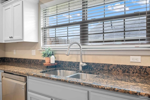 kitchen featuring white cabinetry, sink, dark stone counters, and dishwasher