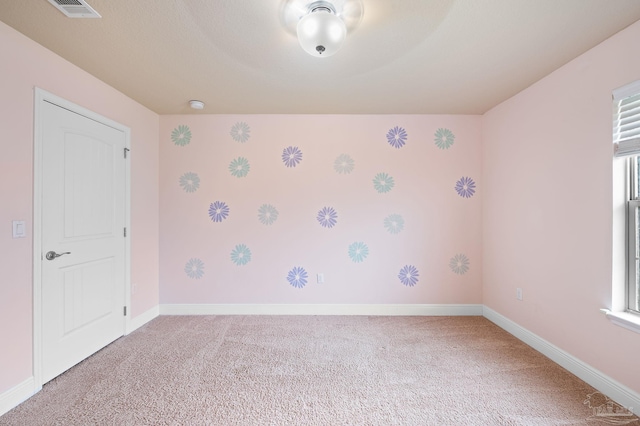 carpeted spare room featuring a wealth of natural light