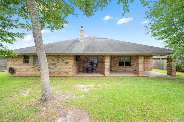 back of house featuring a patio area and a lawn