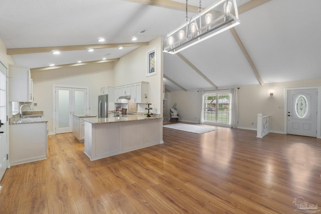 4507 Whisper Way, Pensacola, FL 32504 - kitchen featuring freestanding refrigerator, white cabinetry, light stone countertops, open floor plan, and light wood-type flooring