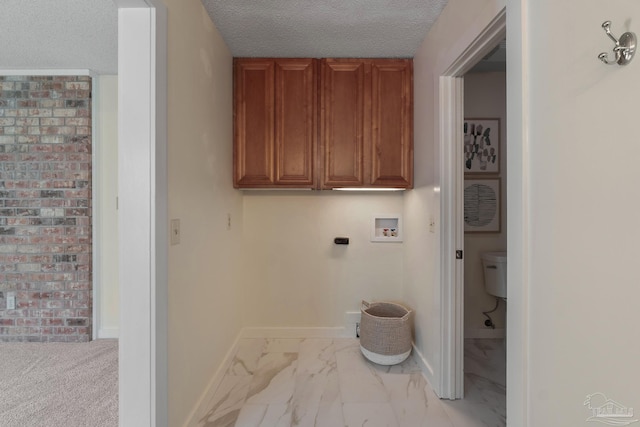 4507 Whisper Way, Pensacola, FL 32504 - laundry area with washer hookup, marble look tile flooring, cabinet space, and a textured ceiling