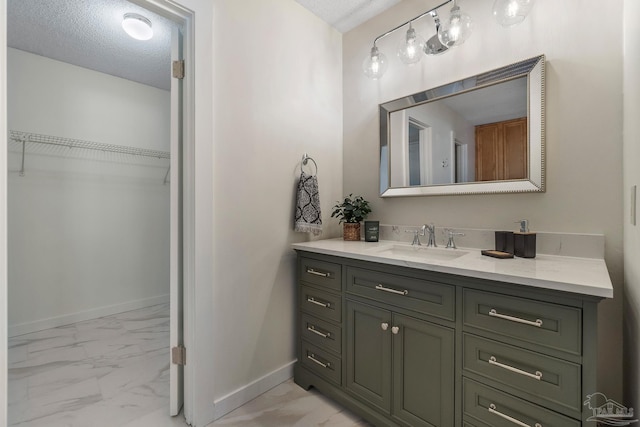 4507 Whisper Way, Pensacola, FL 32504 - bathroom with marble finish floors, vanity, a walk in closet, and a textured ceiling