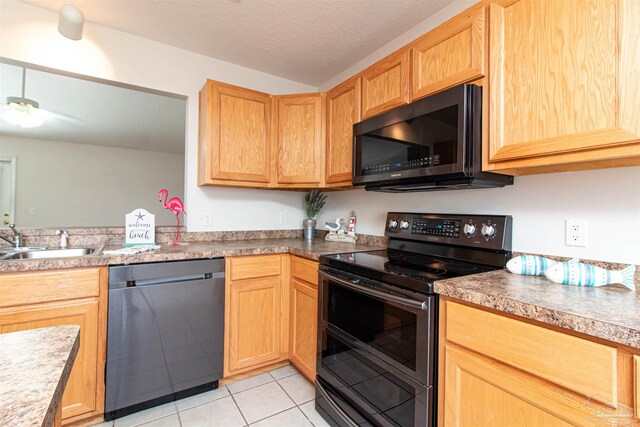 kitchen featuring ceiling fan, light tile patterned floors, sink, a textured ceiling, and stainless steel appliances