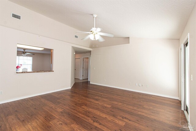 empty room with lofted ceiling, ceiling fan, dark wood-type flooring, and a textured ceiling