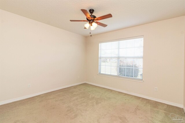 empty room with ceiling fan and light carpet