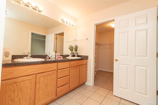 bathroom with tile patterned floors, vanity, and a textured ceiling