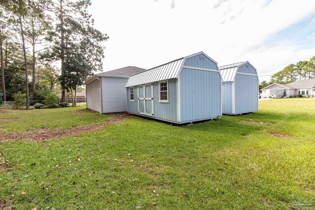 back of house with a yard and a storage unit