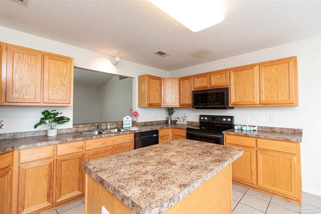 kitchen with a textured ceiling, a center island, sink, and black appliances