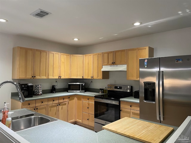 kitchen featuring stainless steel appliances, light brown cabinets, and sink