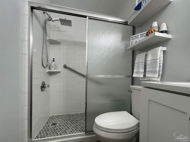 bathroom with a shower with shower door, toilet, and vanity