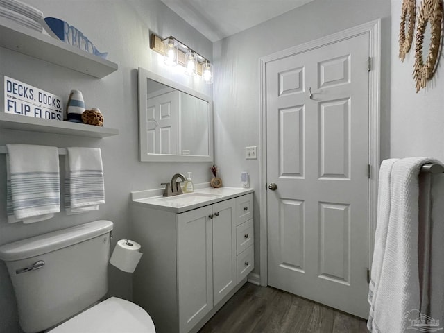 bathroom with vanity, toilet, and hardwood / wood-style floors