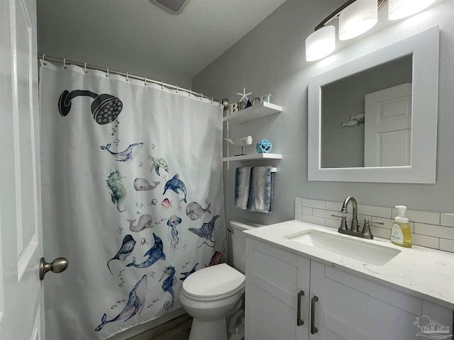 bathroom featuring toilet, tasteful backsplash, and vanity