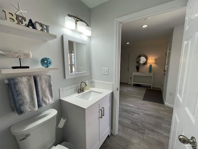 bathroom with vanity, tasteful backsplash, hardwood / wood-style flooring, and toilet