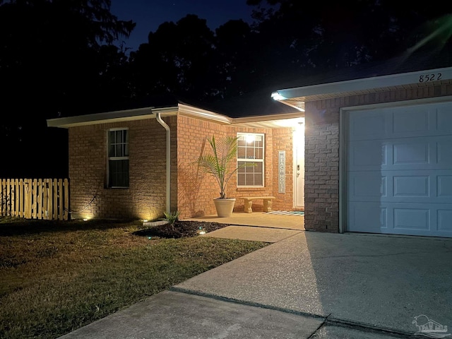 ranch-style home with a garage and a yard