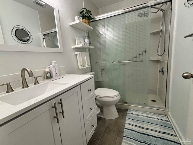 bathroom featuring vanity, walk in shower, hardwood / wood-style flooring, and toilet