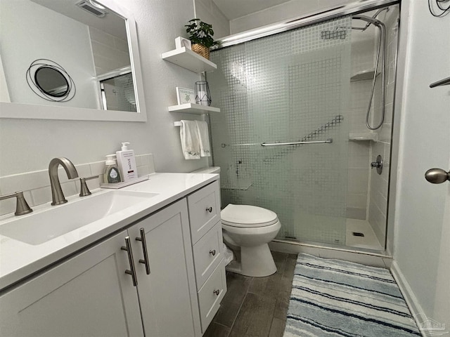 bathroom featuring walk in shower, vanity, toilet, and wood-type flooring