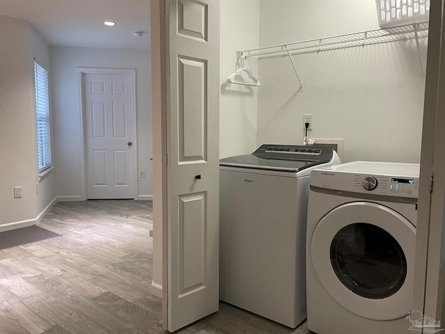 washroom with light wood-type flooring and washer and dryer