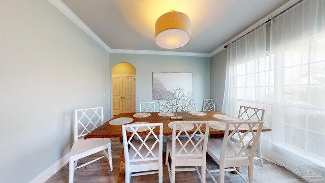 265 Tropical Breeze Dr, Santa Rosa Beach, FL 32459 - dining space with arched walkways, ornamental molding, baseboards, and wood finished floors