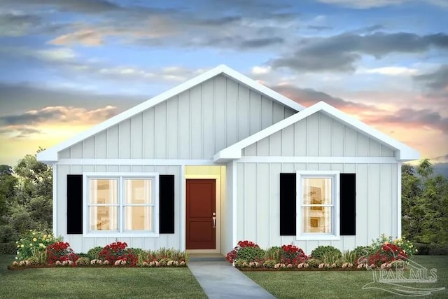 view of front of property with board and batten siding and a lawn
