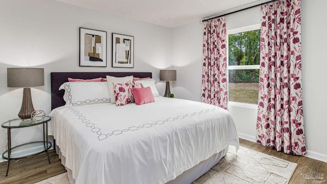 bedroom with baseboards and wood finished floors