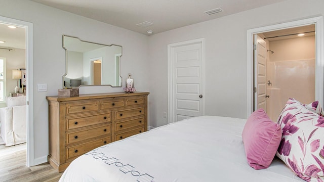 bedroom with visible vents, light wood-type flooring, ensuite bath, and recessed lighting
